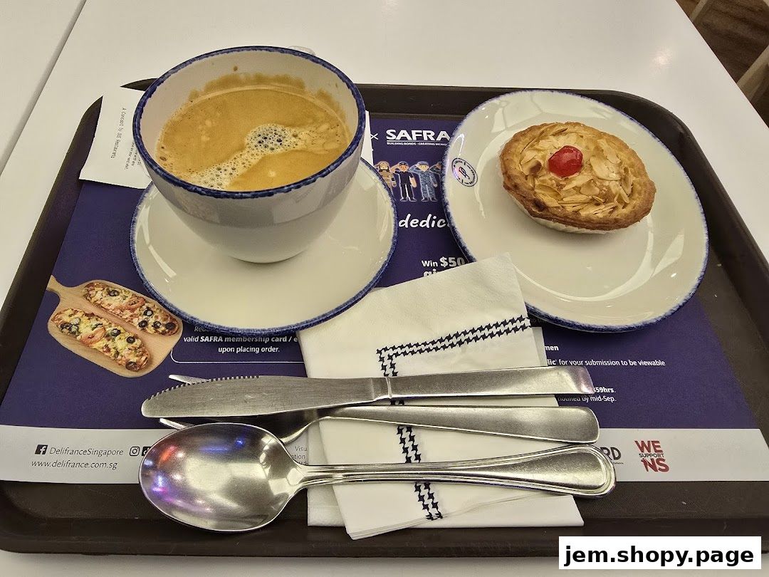 A tray with coffee, a pastry, and cutlery from Délifrance.