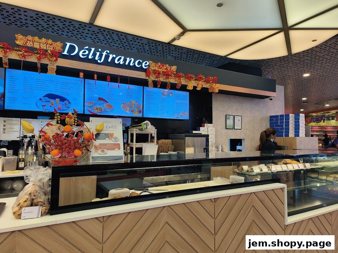 Délifrance bakery and coffee shop counter with digital menus and display of pastries.