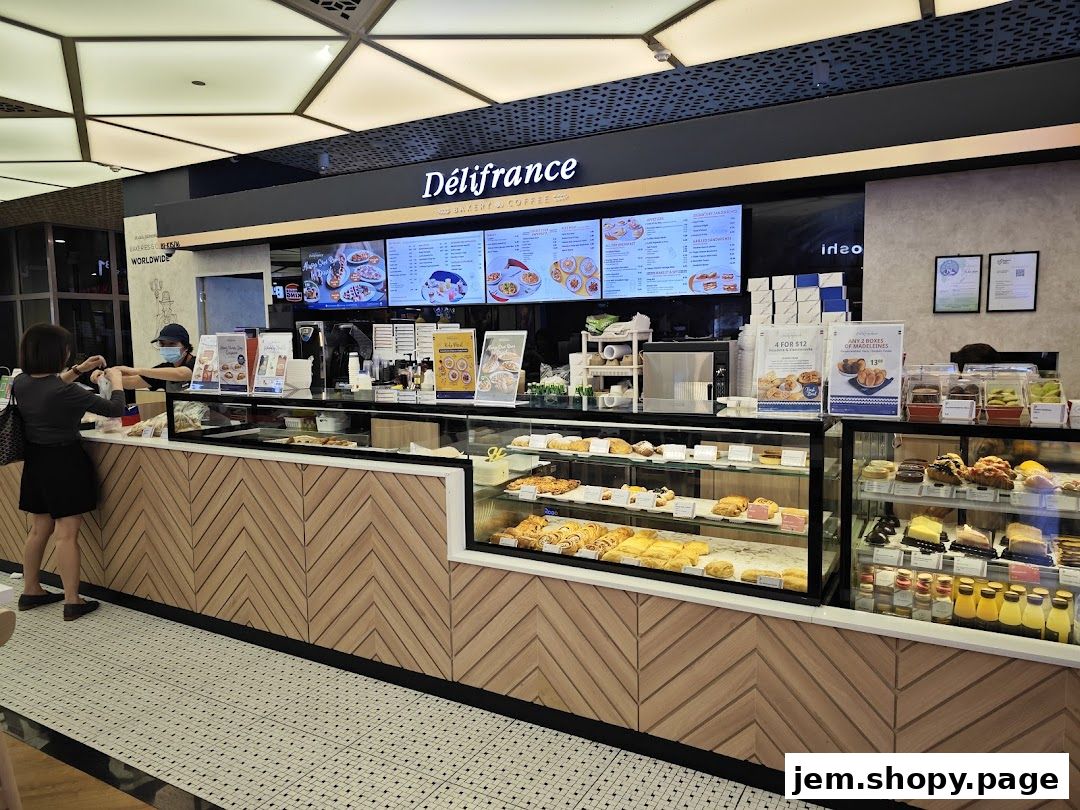 A customer is served at the counter of a Délifrance bakery and coffee shop.