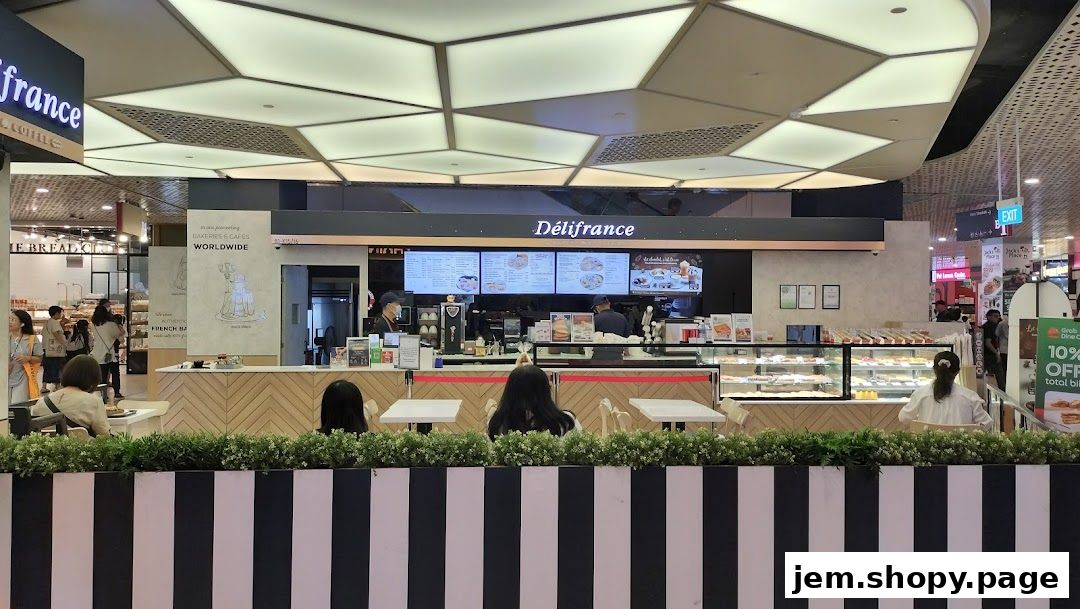 A Délifrance bakery and cafe with display cases of pastries and a menu board.
