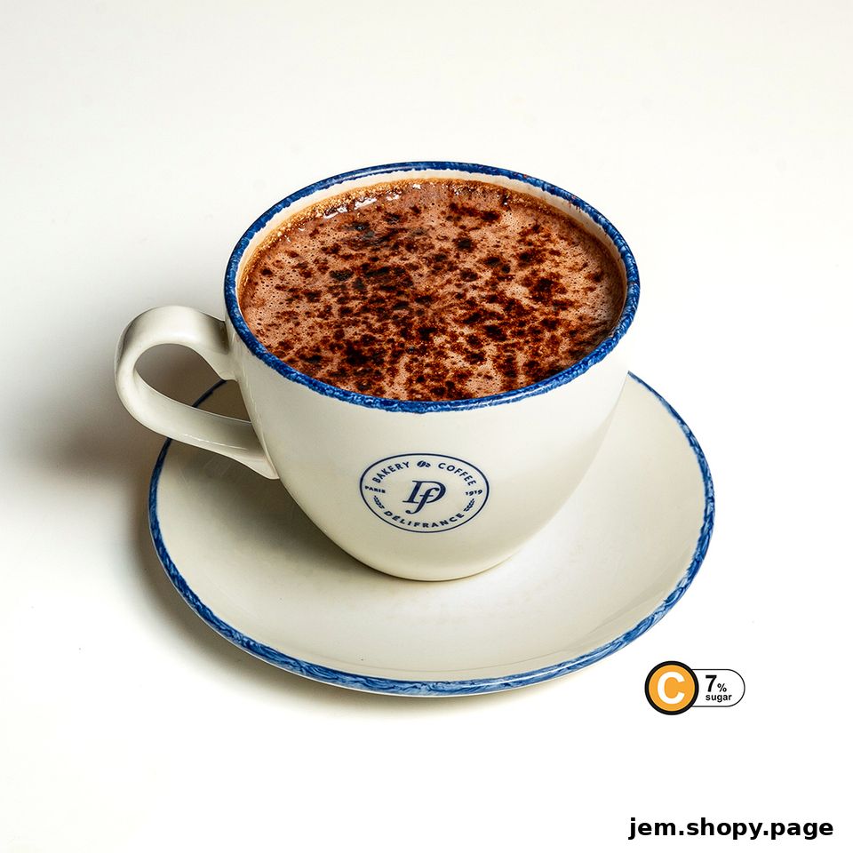 A close-up shot of a hot chocolate drink in a white cup with blue trim.