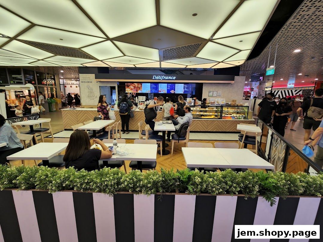 Interior view of a Délifrance cafe with customers and display cases of pastries.