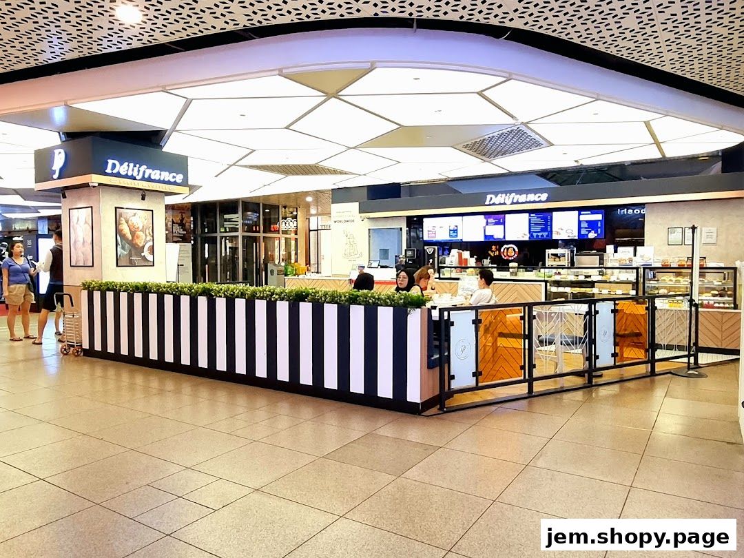 The exterior of a Délifrance bakery and cafe with seating and display cases.
