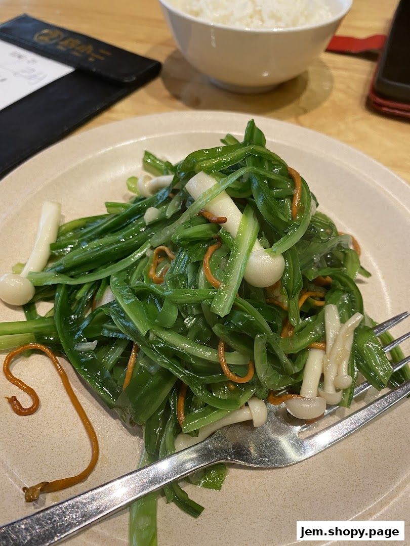 A plate of stir-fried vegetables with mushrooms and a bowl of rice.