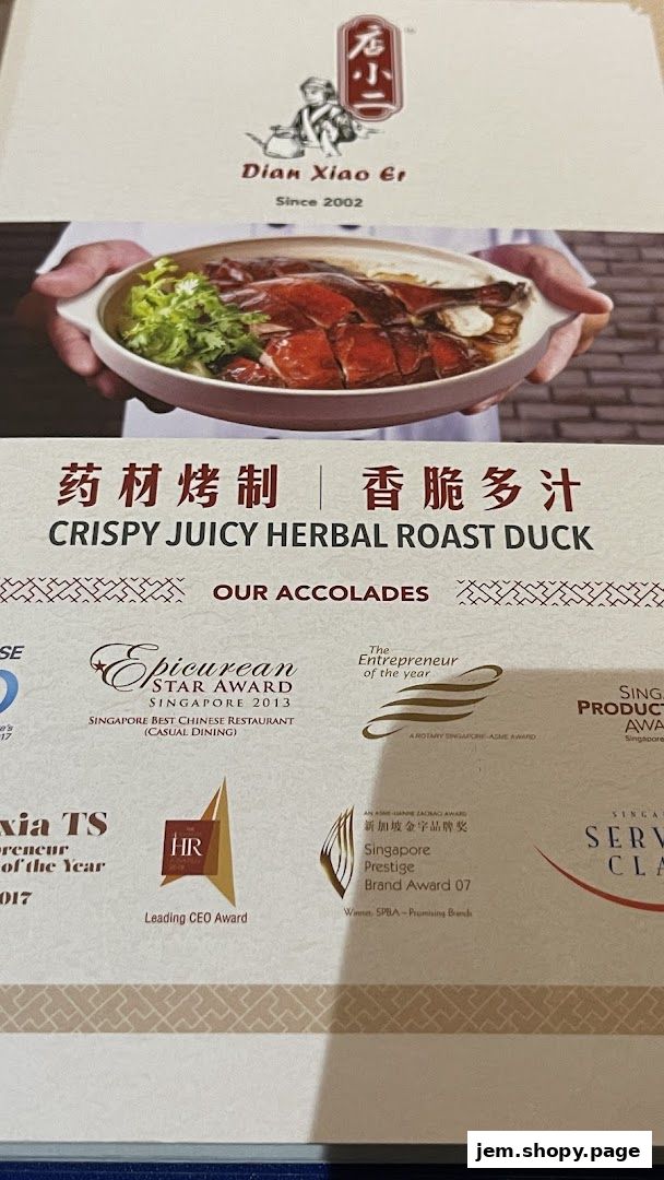 A close-up of Dian Xiao Er's Crispy Juicy Herbal Roast Duck with accolades.