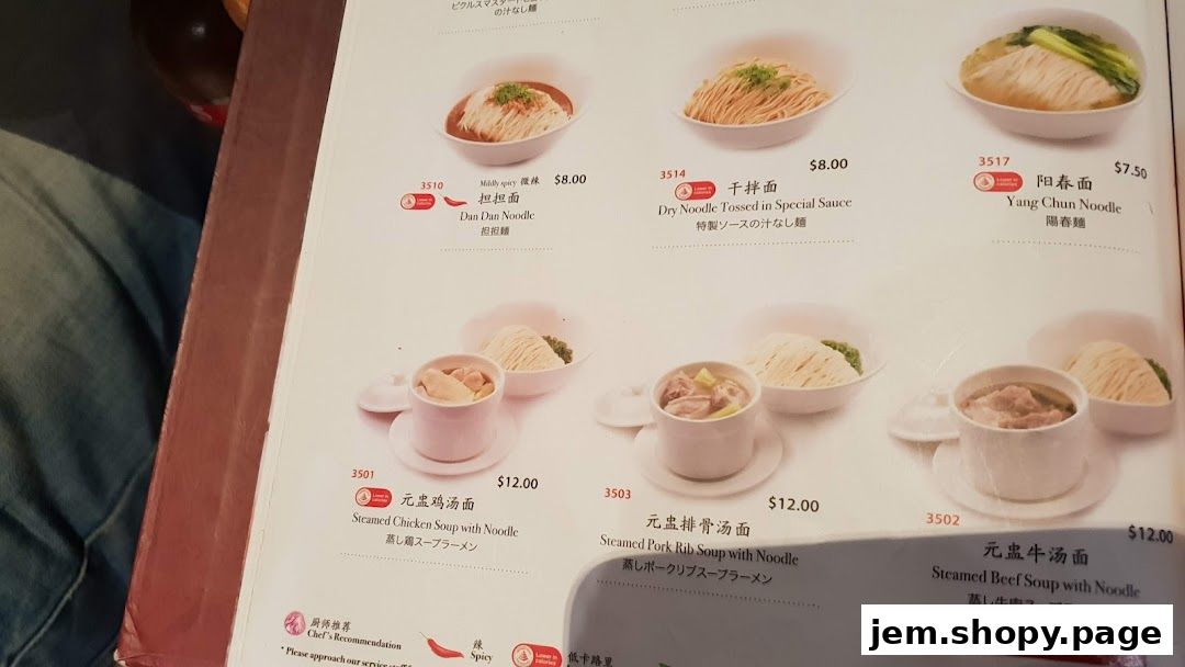 A menu from Din Tai Fung featuring various noodle and soup dishes with prices.