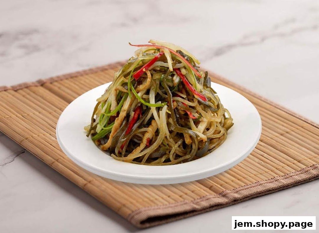 A plate of seaweed salad with shredded vegetables on a bamboo mat.