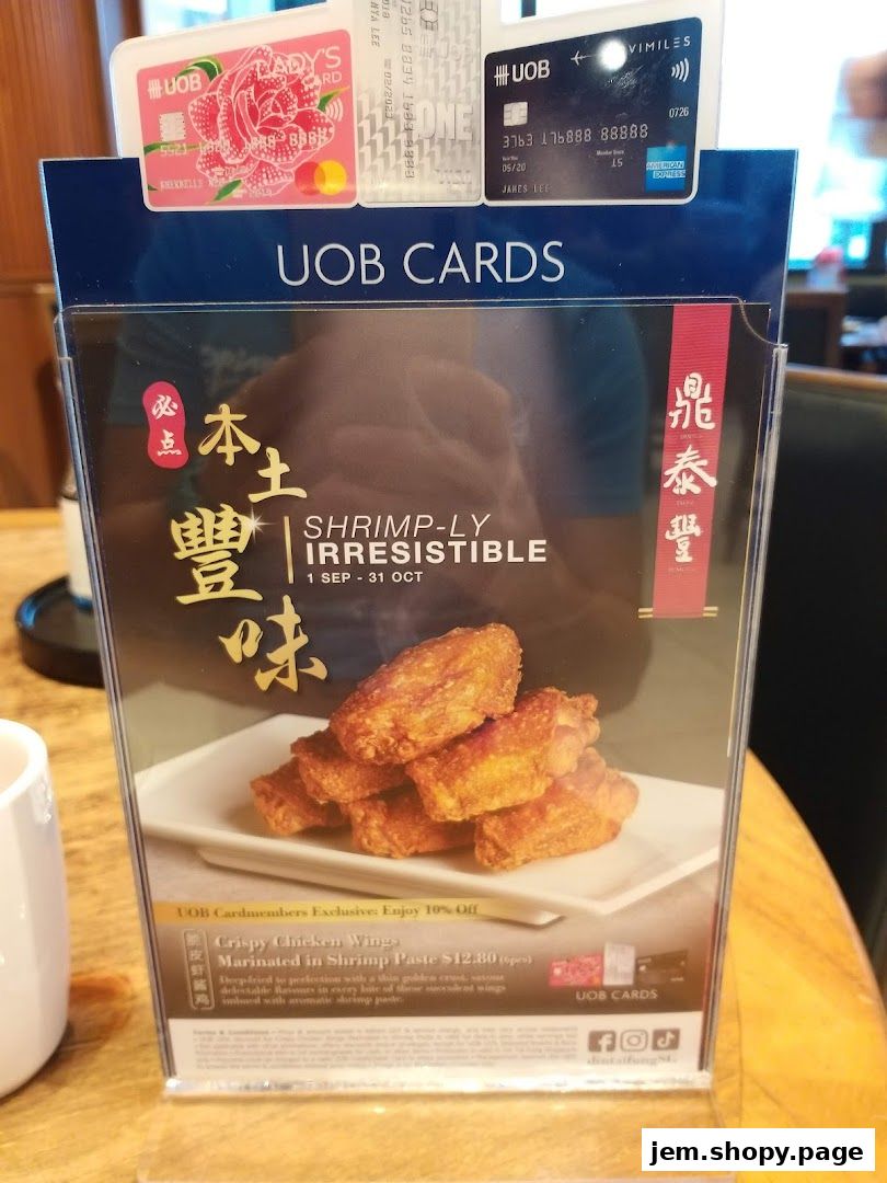 A promotional sign for Din Tai Fung featuring crispy chicken wings and UOB card offers.