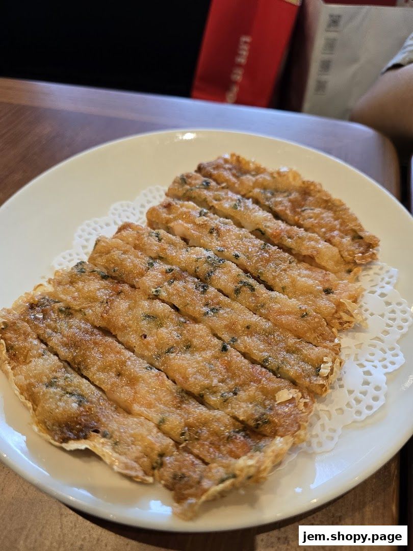 A plate of crispy fried shrimp cakes with herbs served on a white doily.