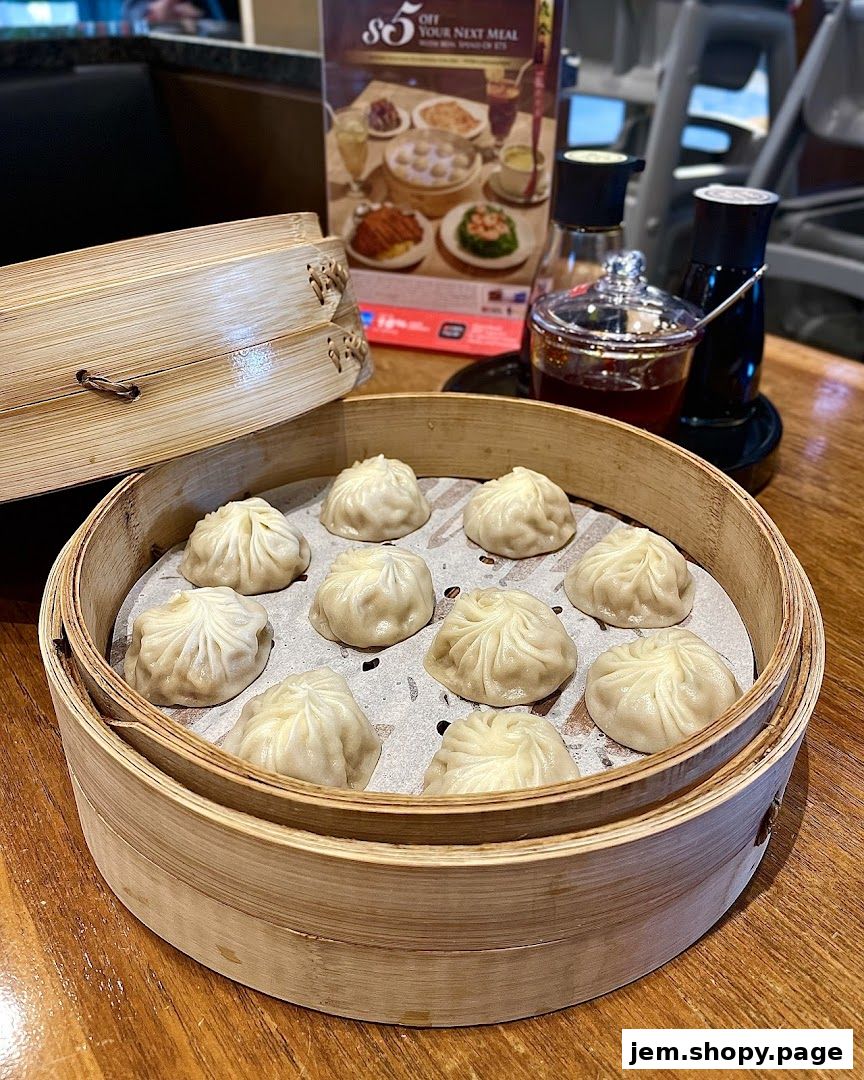 A bamboo steamer basket filled with delicious soup dumplings on a wooden table.