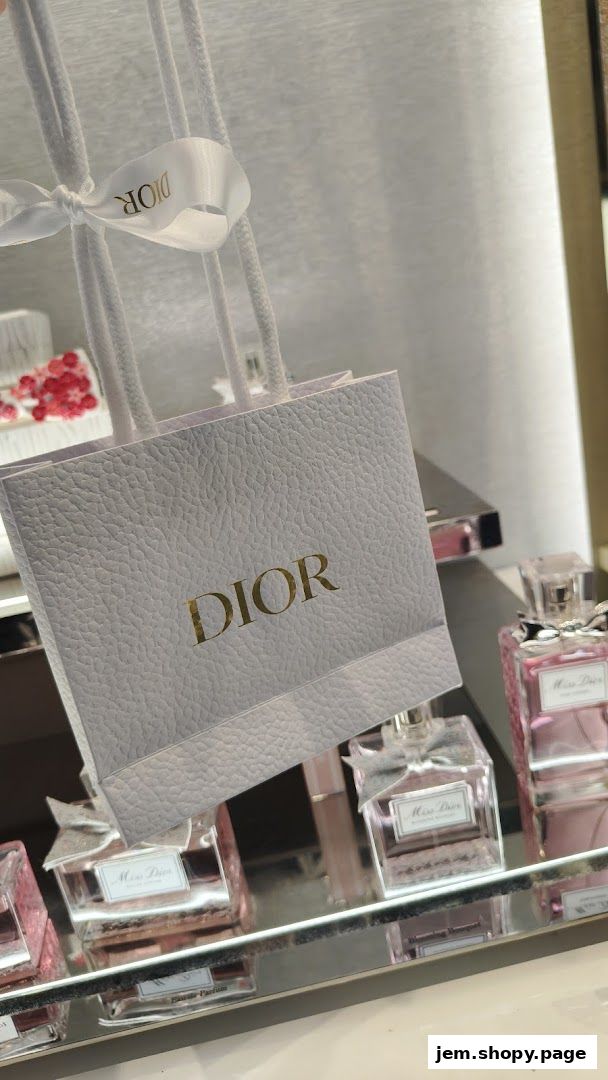 A Dior shopping bag and Miss Dior perfume bottles displayed on a shelf.