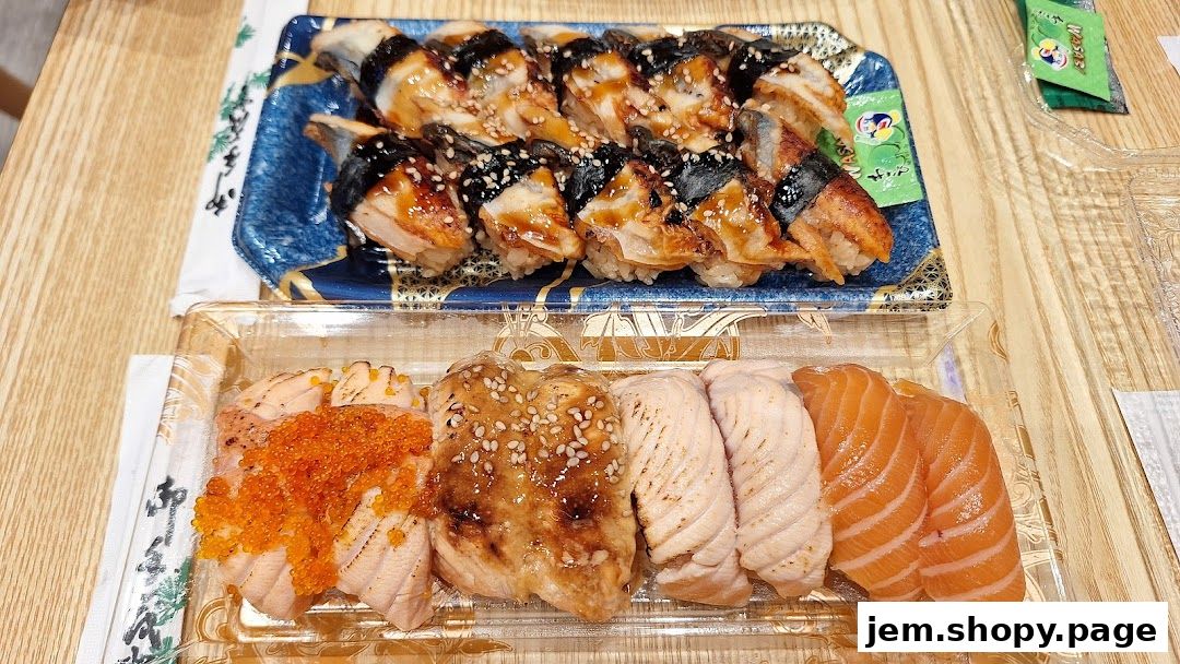 Two trays of sushi, one with eel and one with salmon, are displayed on a wooden table.