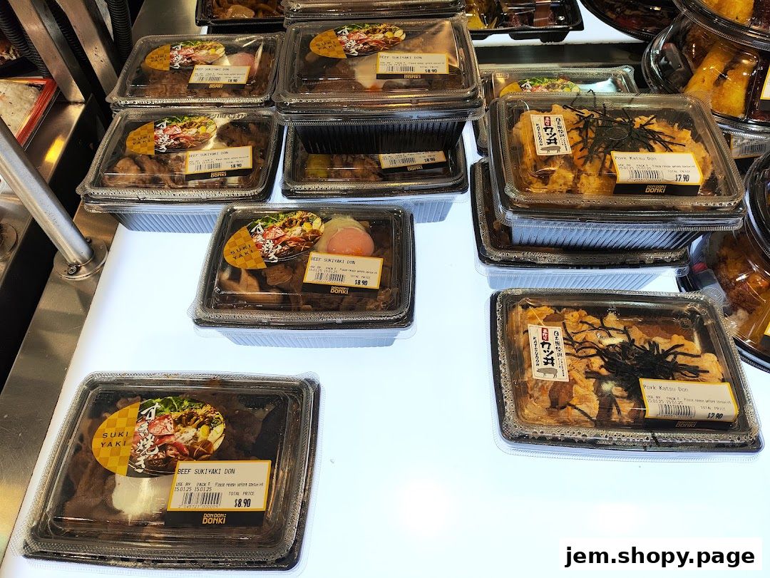 Pre-packaged Japanese rice bowls with beef and pork katsu are displayed for sale.