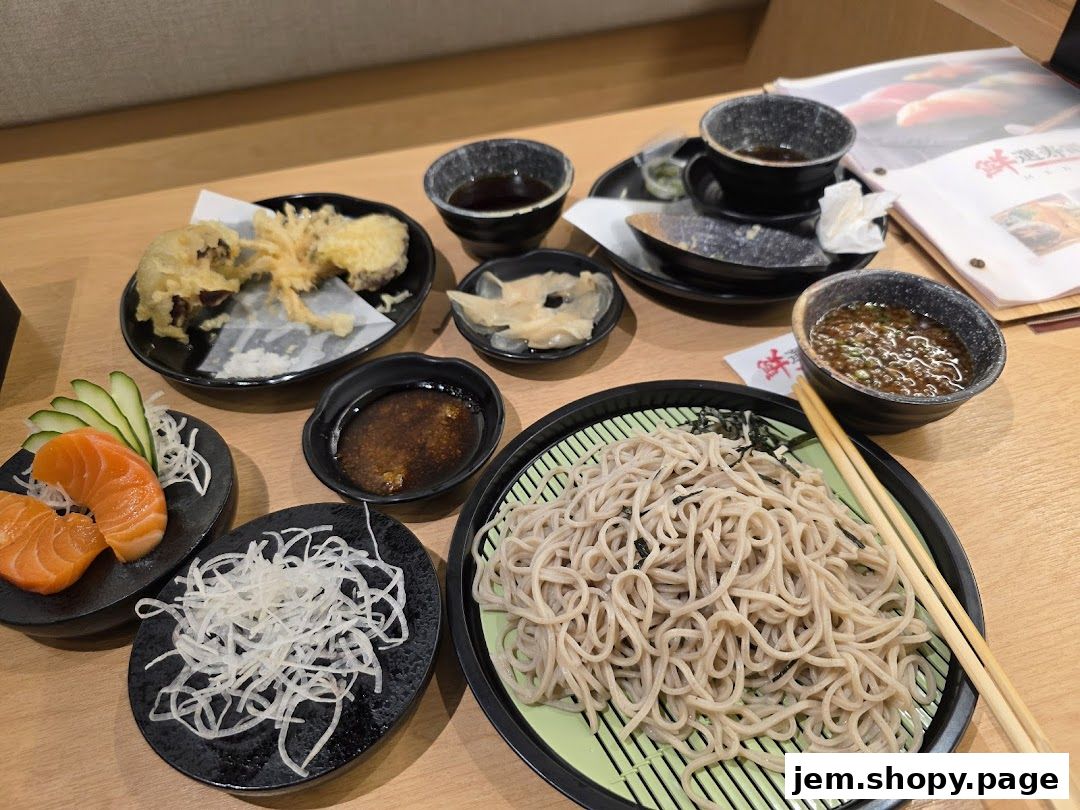 A table laden with Japanese dishes including soba noodles, tempura, and sashimi.