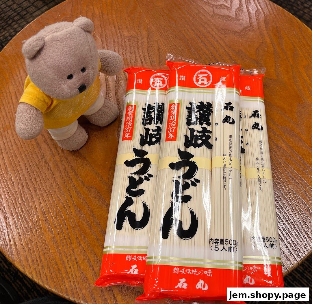 A teddy bear sits next to three packages of udon noodles on a wooden table.
