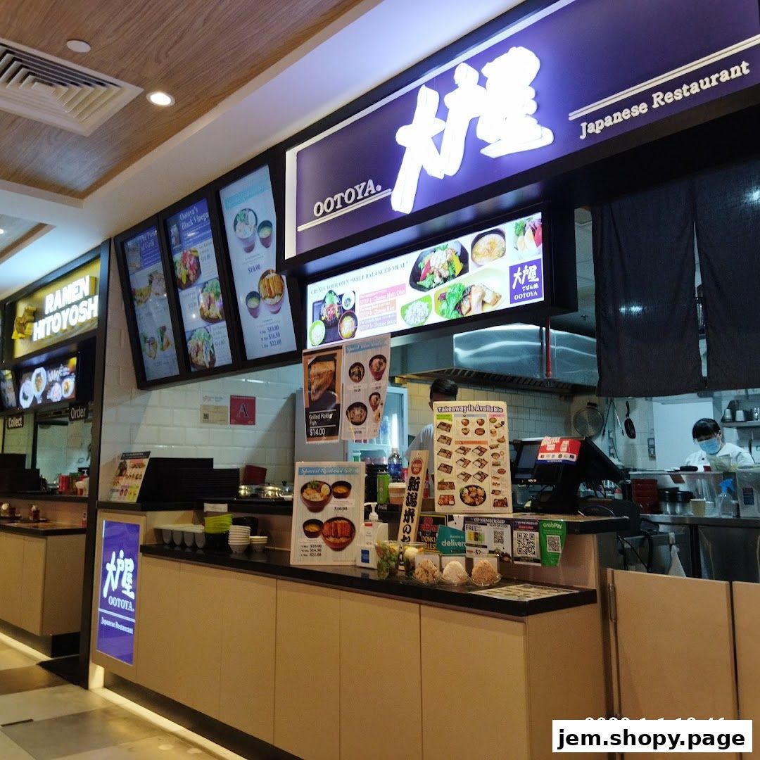 Interior view of a Japanese restaurant counter with menu displays and food items.