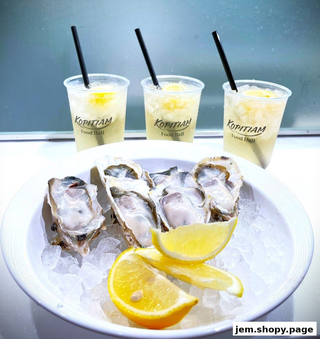 Fresh oysters on ice with lemon wedges and three iced beverages.