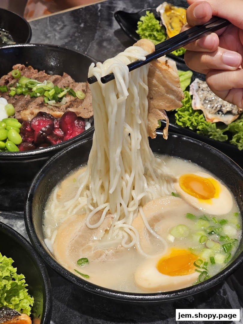 A close-up shot of a steaming bowl of ramen with pork and a soft-boiled egg.