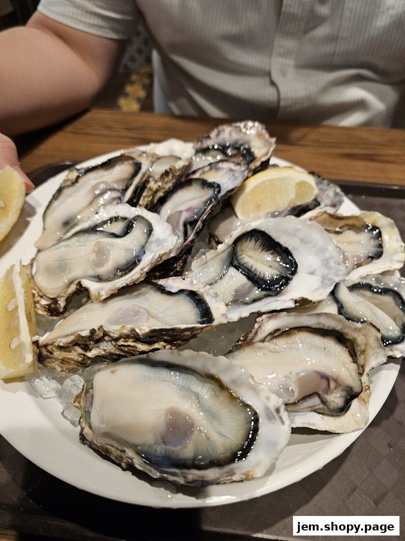 A plate of fresh oysters served with lemon wedges on ice.