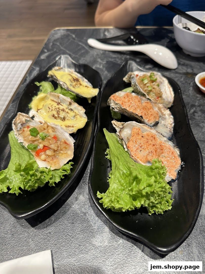 Two black plates each holding three oysters topped with various savory ingredients.