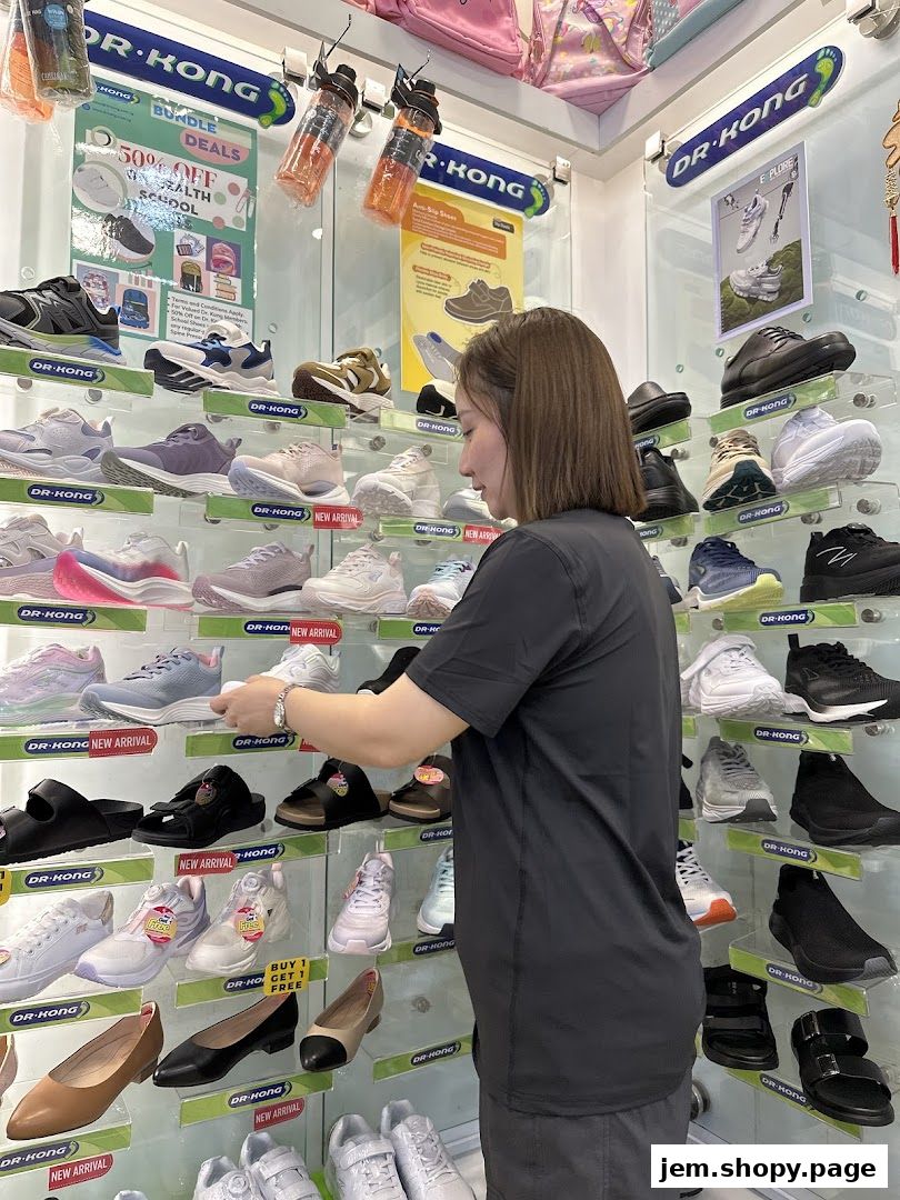 A woman browses a wide selection of shoes displayed on shelves in a Dr. Kong store.