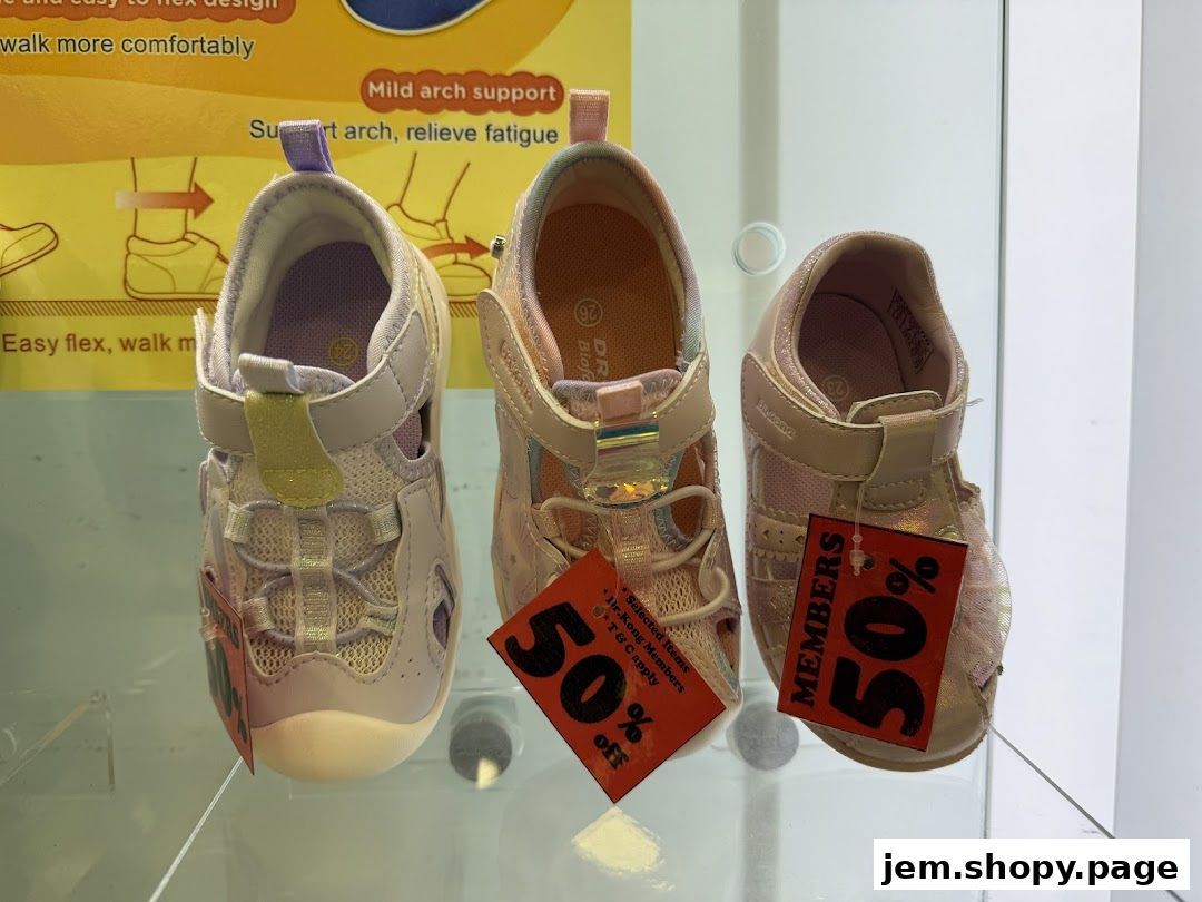 Three pairs of children's sandals are displayed with sale tags.