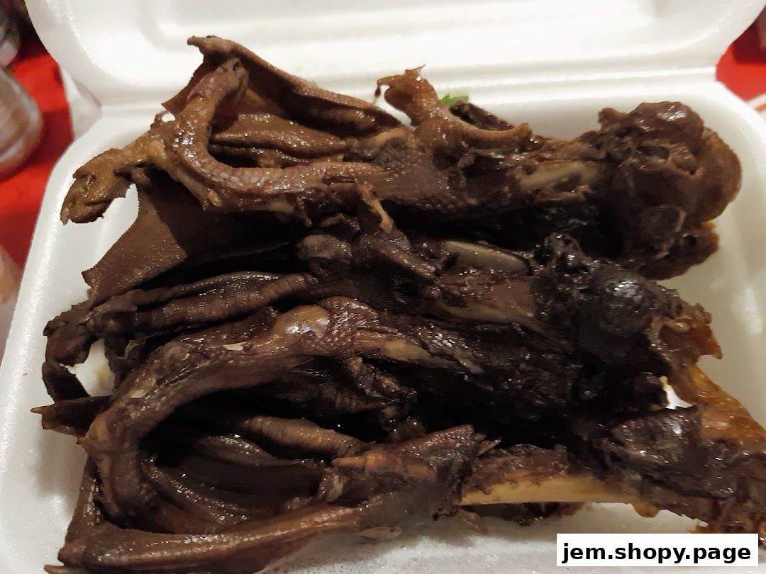 A close-up of braised duck parts in a white styrofoam container.