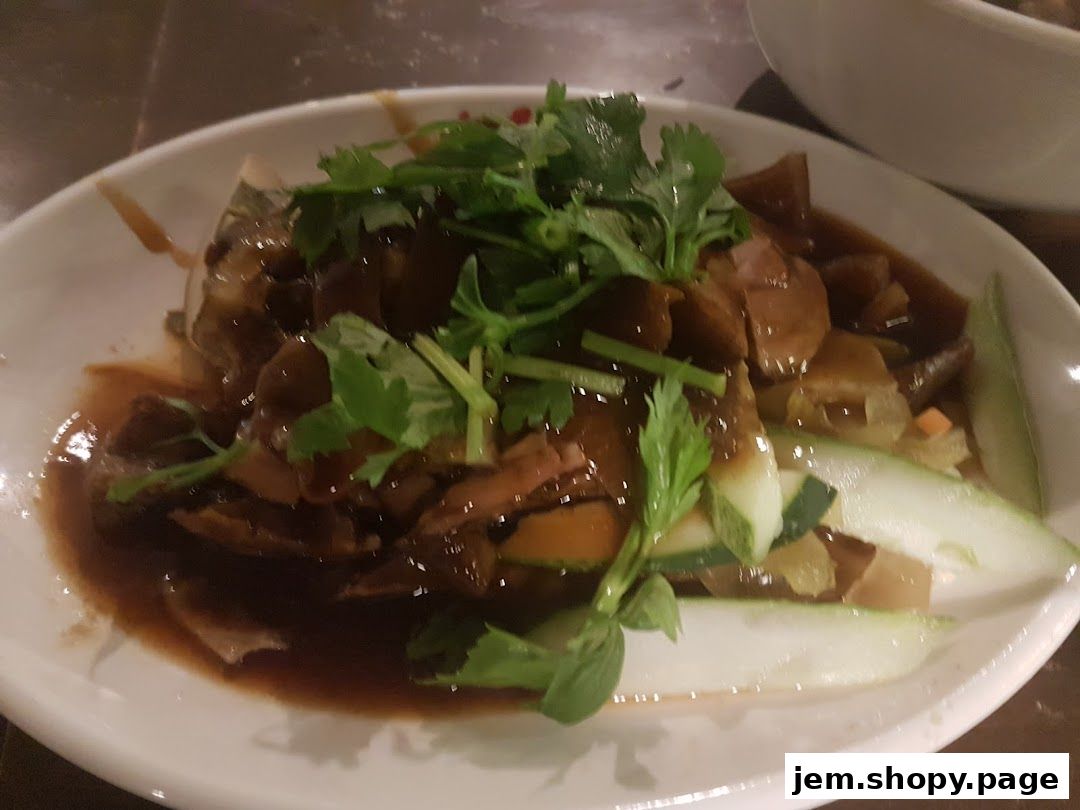 A plate of braised duck and vegetables in a savory sauce, garnished with cilantro.