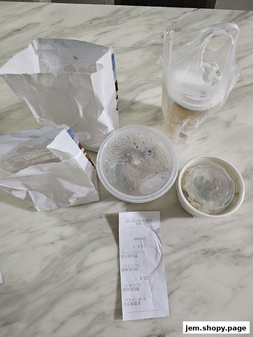 Takeaway food containers, paper bags, and a drink from Eat 3 Bowls.