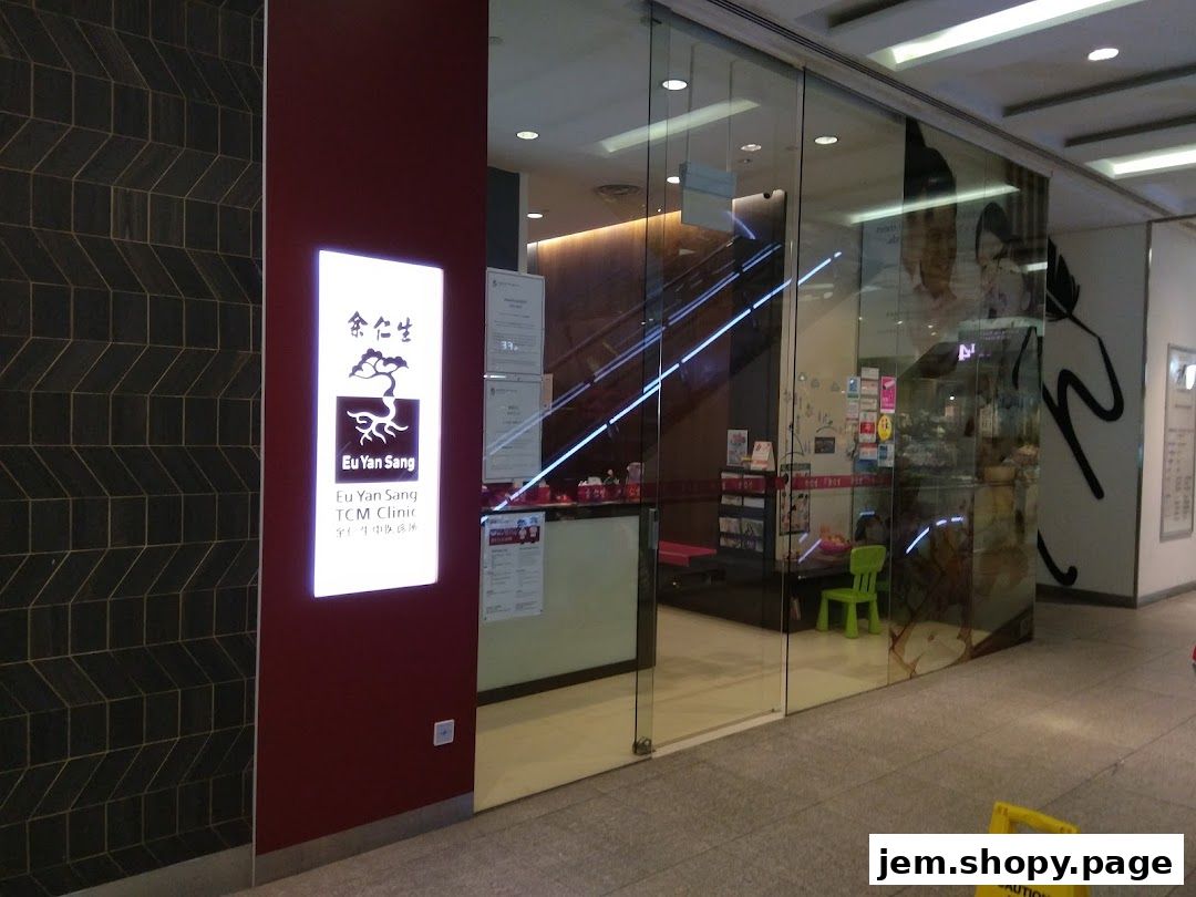 The entrance of Eu Yan Sang TCM Clinic at JEM, featuring a glowing sign and glass doors.