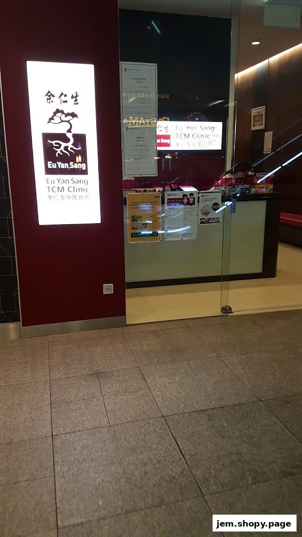 The entrance of Eu Yan Sang TCM Clinic with its illuminated sign and glass doors.