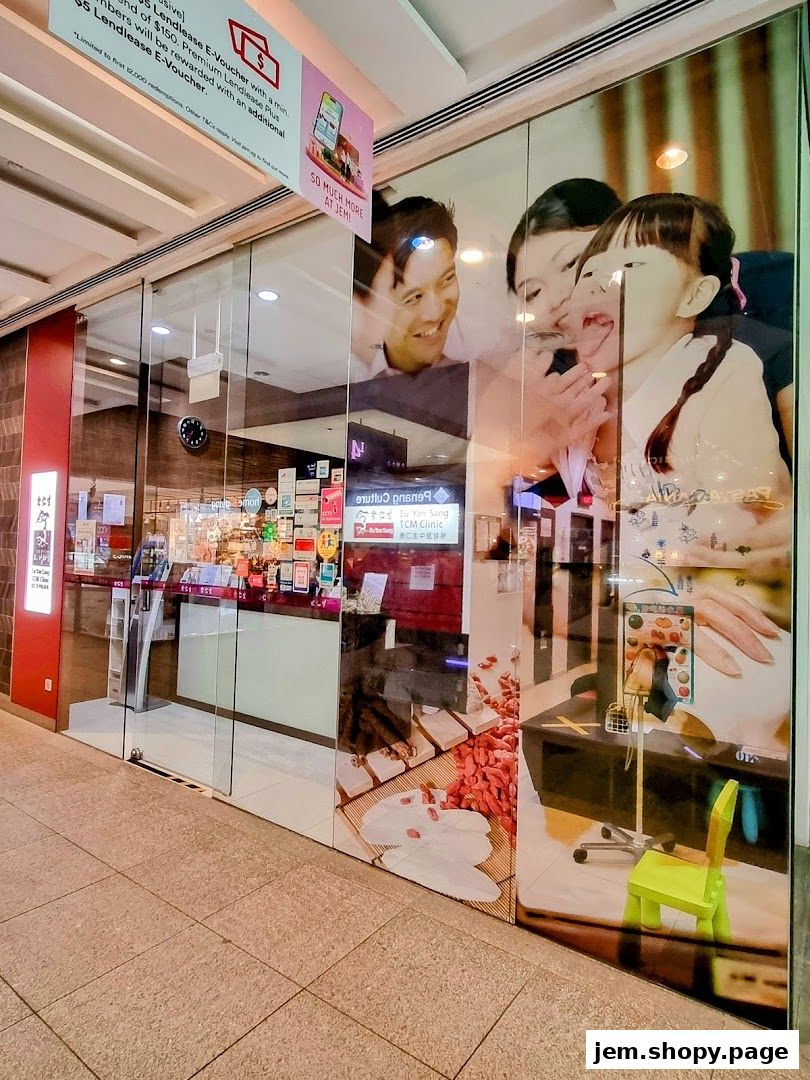 The exterior of Eu Yan Sang TCM Clinic at JEM, featuring a family image and promotional signage.