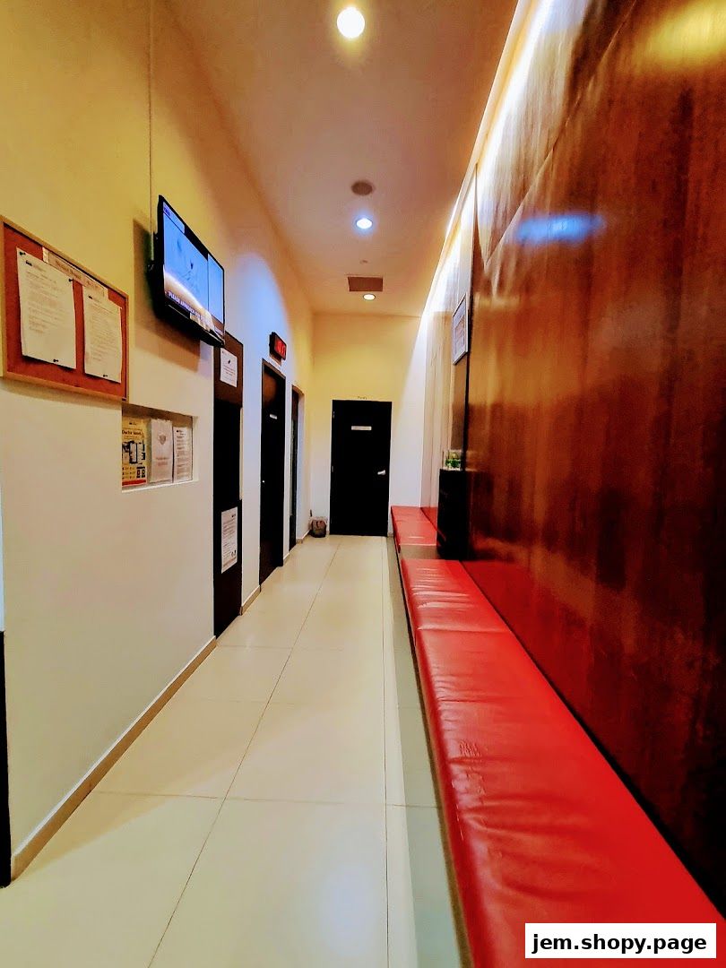 Interior hallway of a clinic with waiting benches and informational displays.