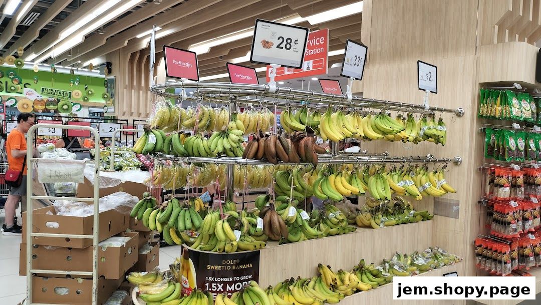 A wide selection of bananas displayed in a supermarket, with prices shown on digital tags.