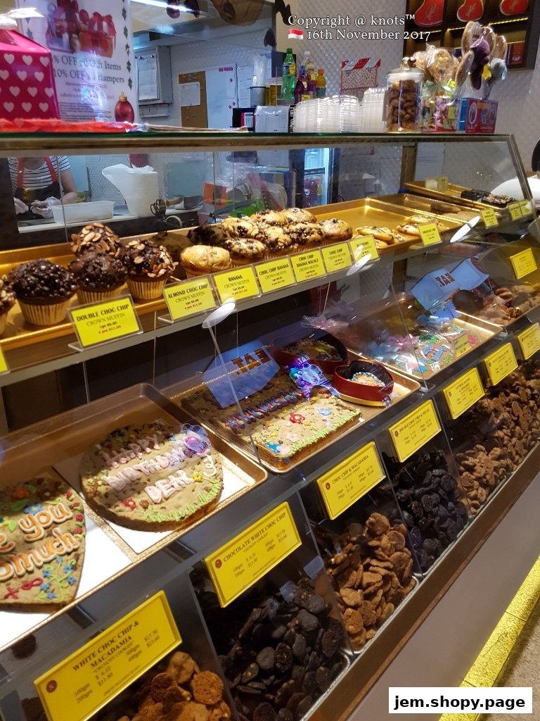 A display case filled with cookies, muffins, and other baked goods at Famous Amos.