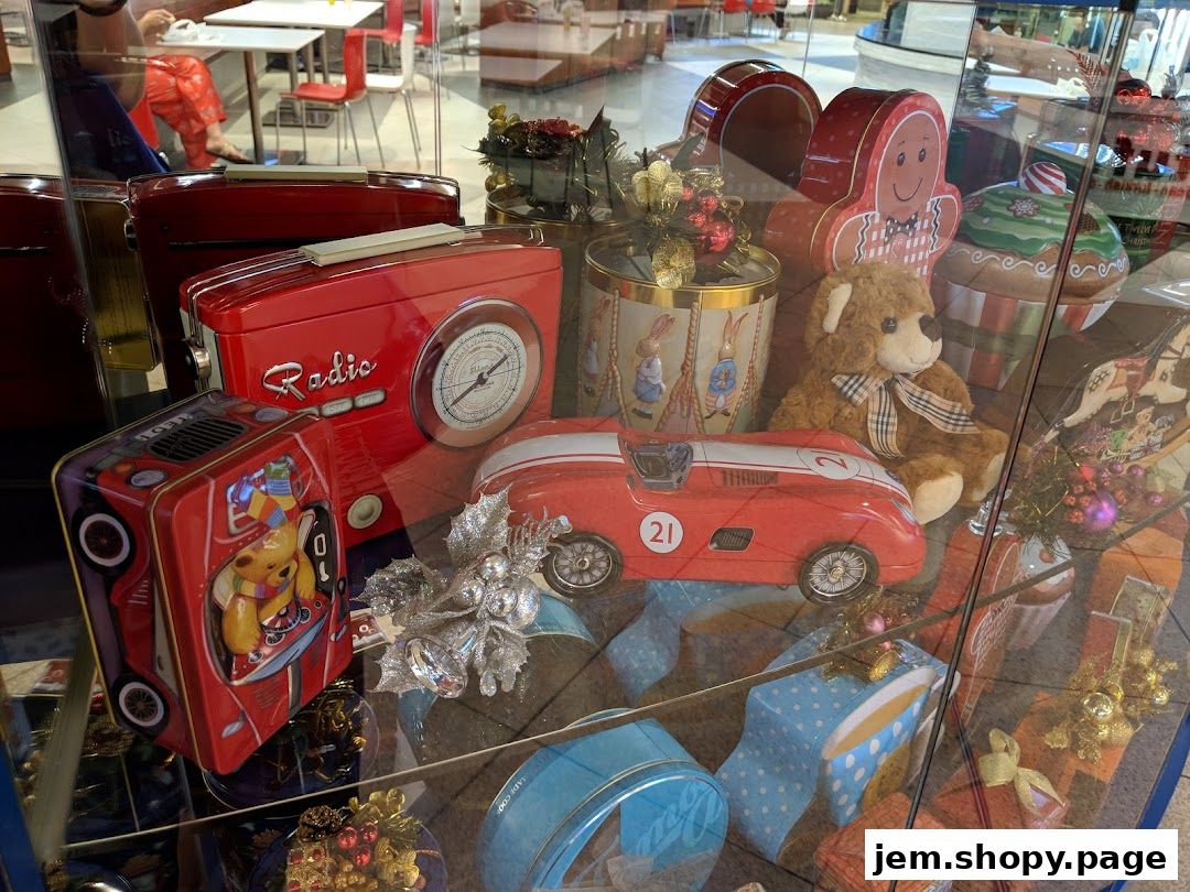 A display of vintage-style red tins and festive decorations in a shop window.