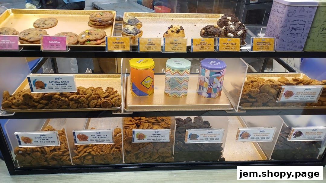 A display of various Famous Amos cookies and decorative tins in a retail setting.
