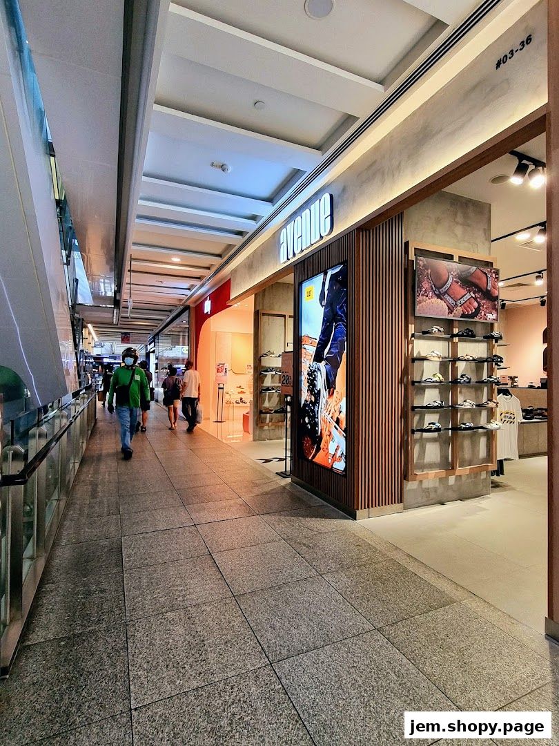 A modern shoe store entrance with a large digital display and shelves of footwear.