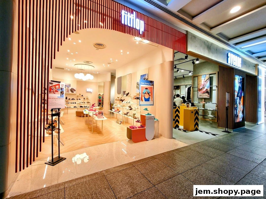The entrance of a FitFlop shoe store displaying various footwear and promotional posters.