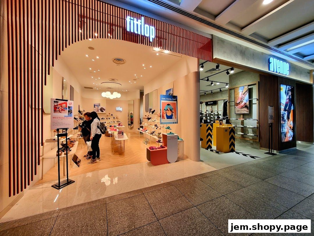 The entrance of a FitFlop shoe store with displays of footwear and promotional posters.