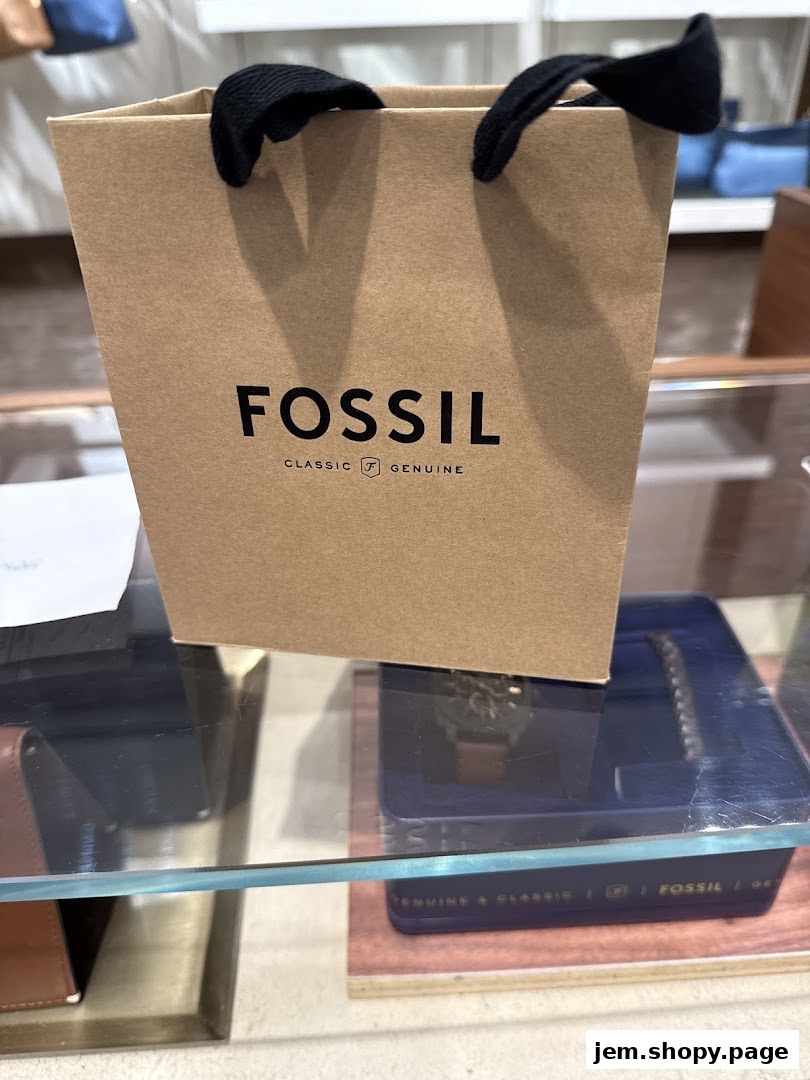 A Fossil shopping bag sits on a display shelf with watches and accessories.