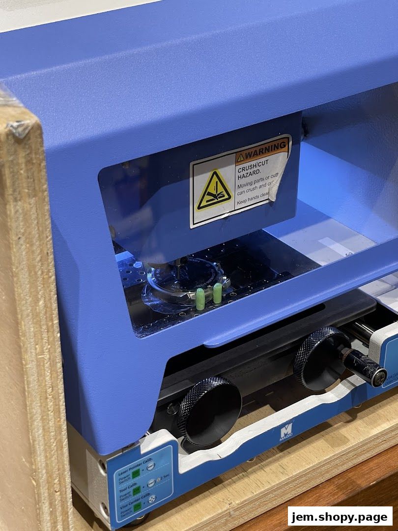 Close-up of a blue industrial machine with warning labels and calibration controls.