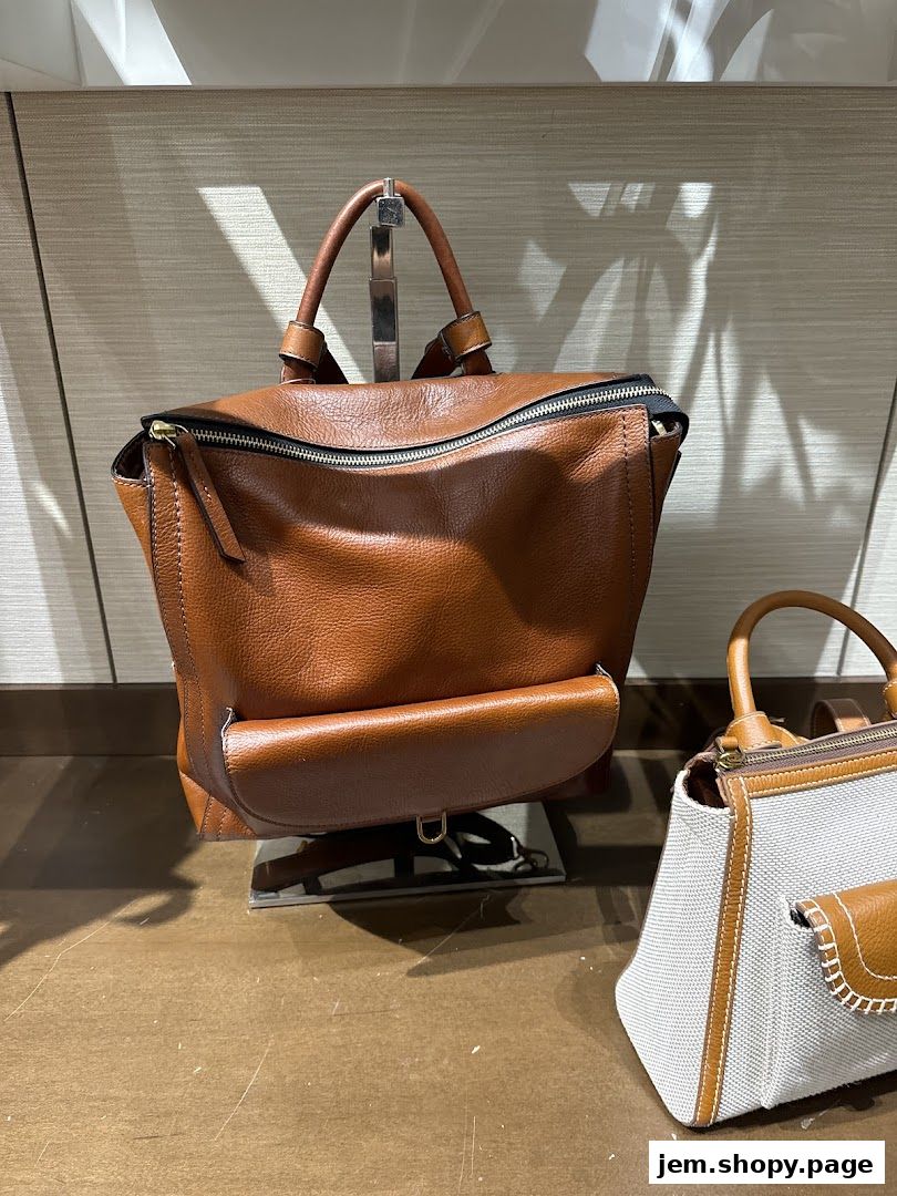 A close-up shot of a brown leather backpack and a canvas handbag on display.