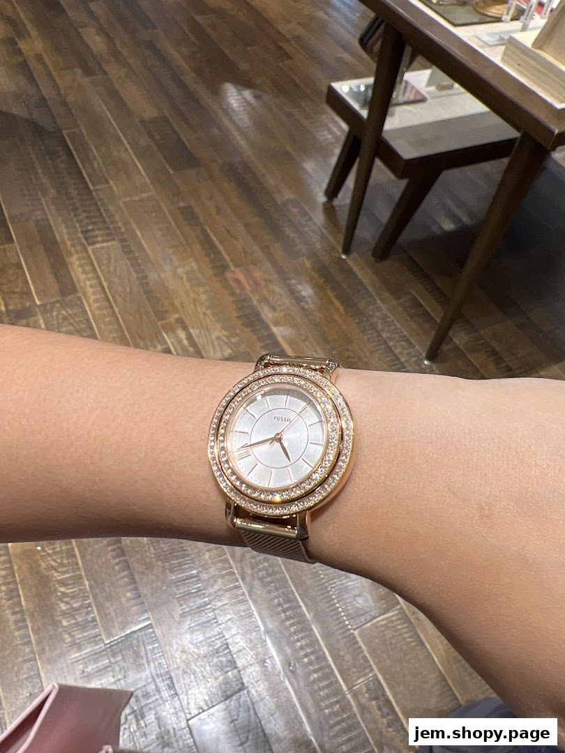 A close-up of a rose gold Fossil watch with a diamond-encrusted bezel on a wrist.