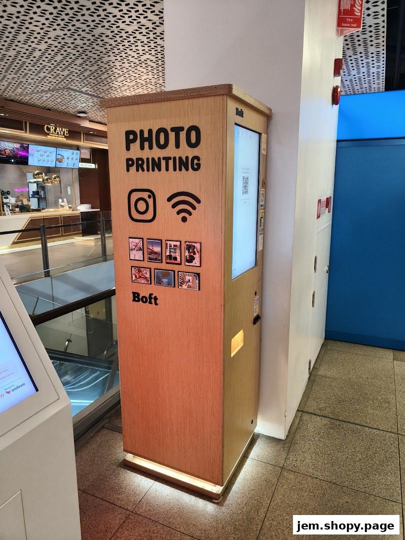 A wooden photo printing kiosk with Instagram and WiFi logos, located in a shopping mall.