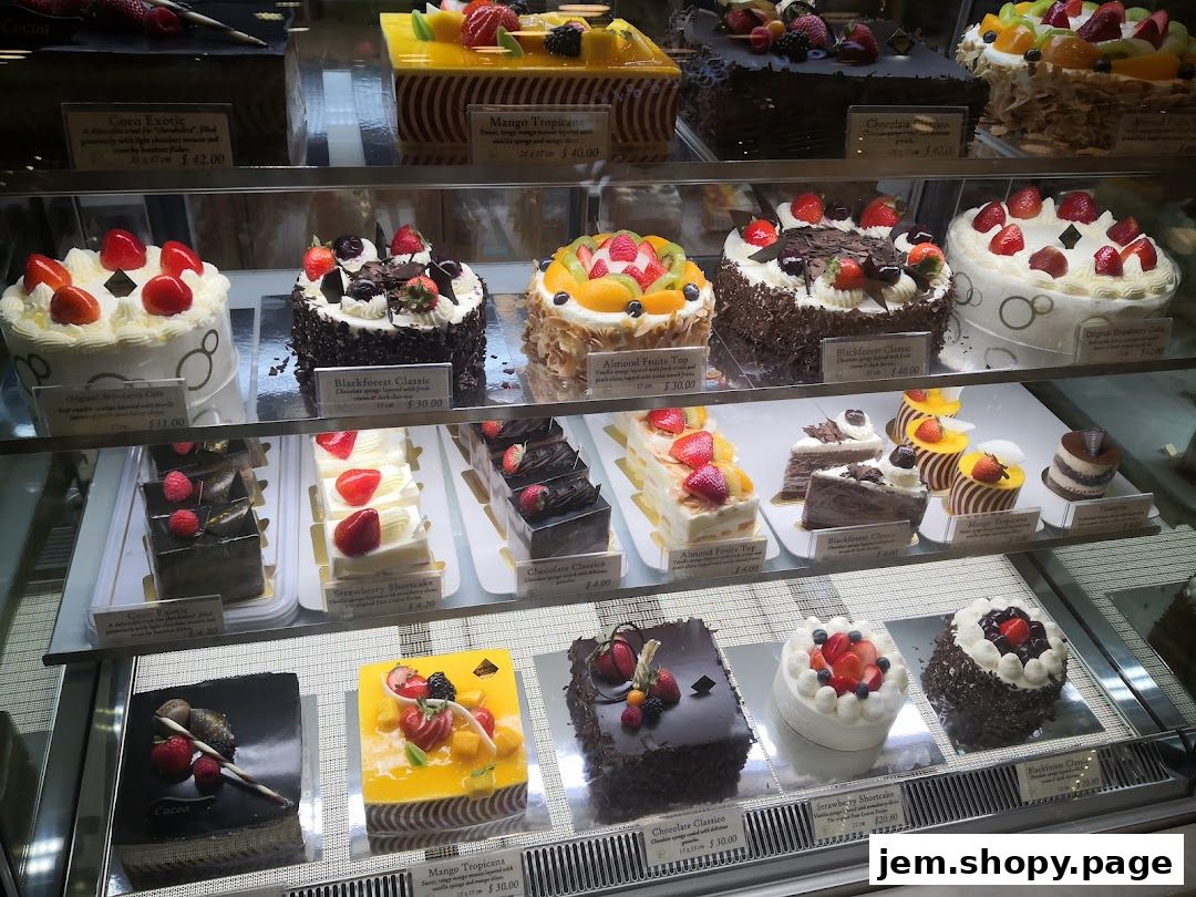 A display case filled with a variety of beautifully decorated cakes and pastries.