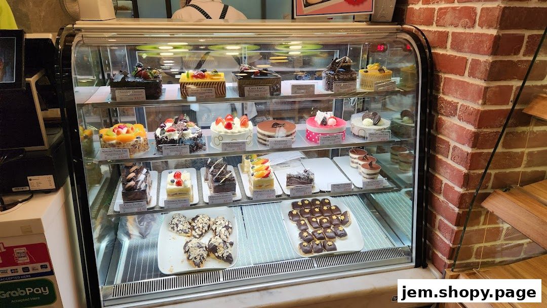 A display case filled with various cakes, pastries, and desserts from Four Leaves bakery.