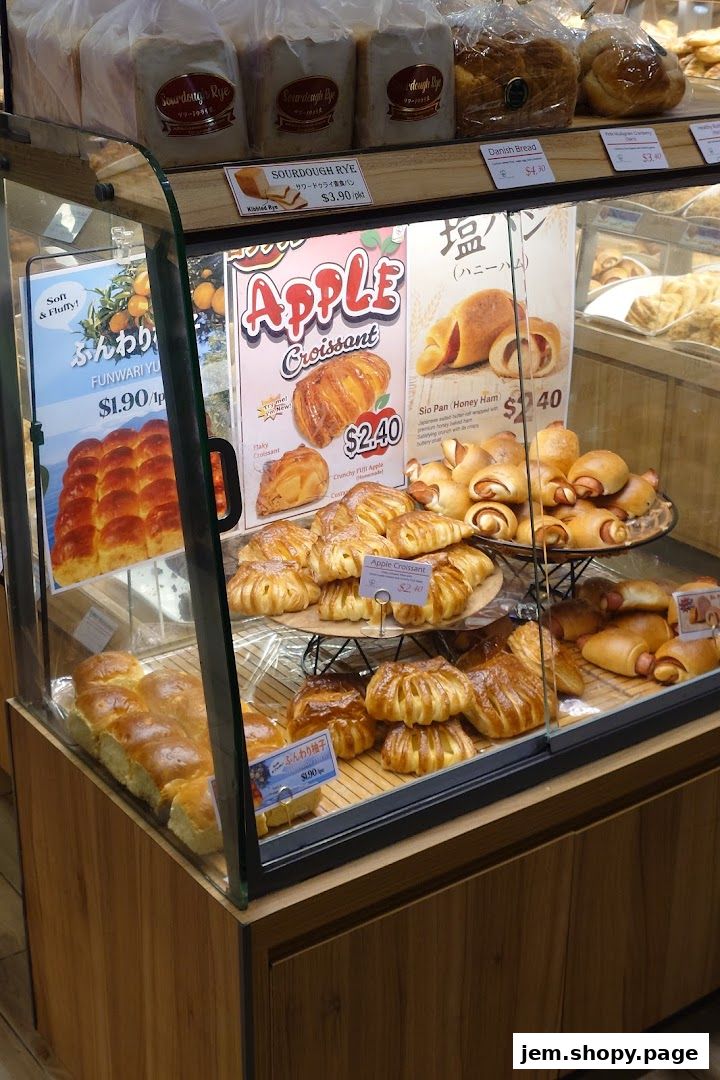 A display case filled with various baked goods, including croissants, bread, and pastries.