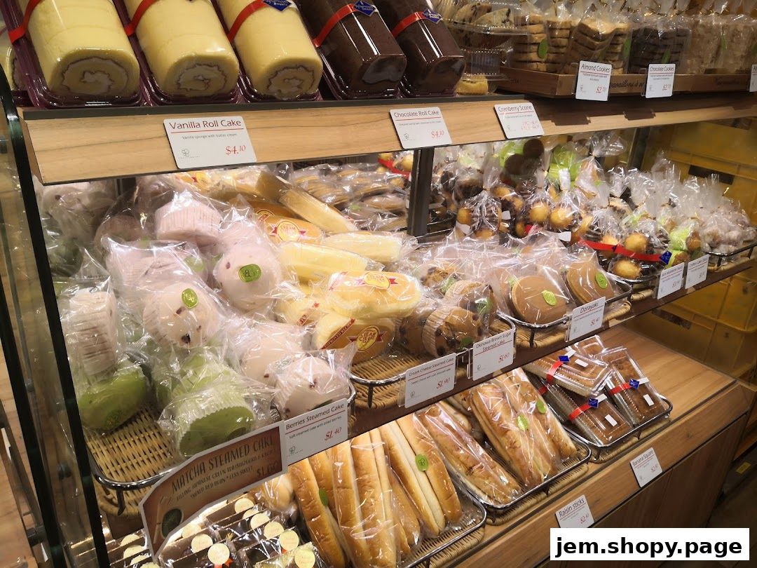 A display of various freshly baked cakes, pastries, and bread in a retail shop.