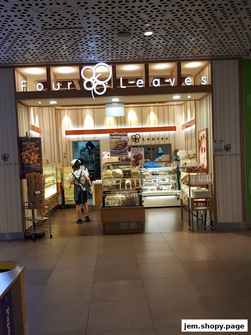 The exterior of a bakery shop named Four Leaves, showcasing display cases filled with baked goods.